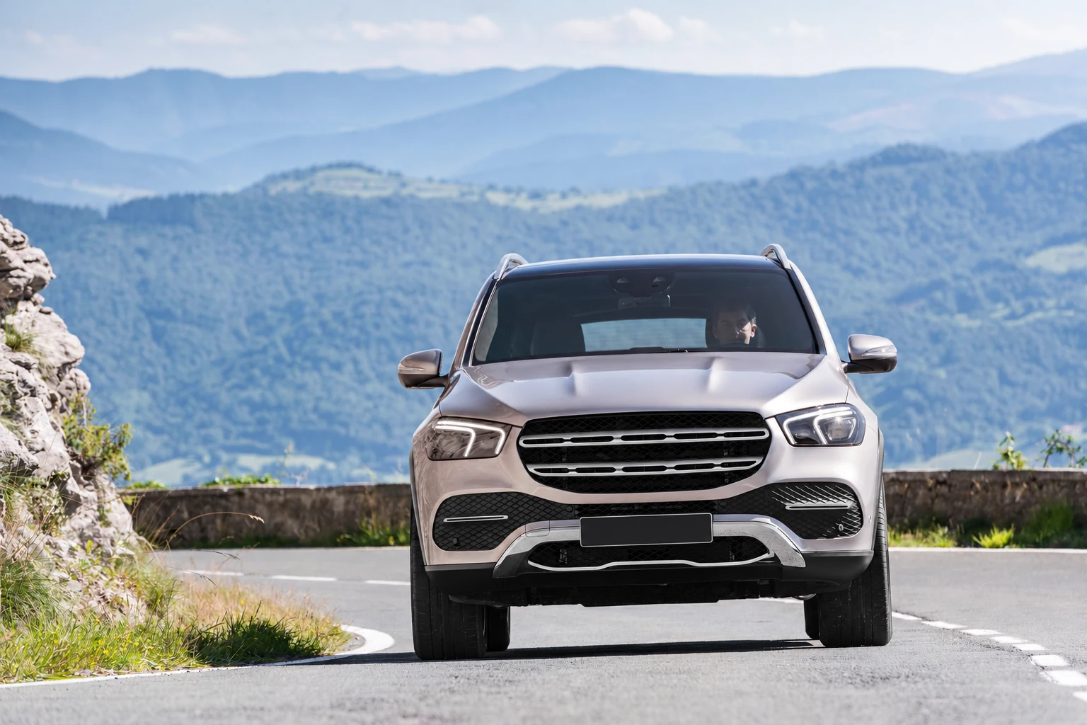 Серебристый Mercedes GLE спереди на горной дороге