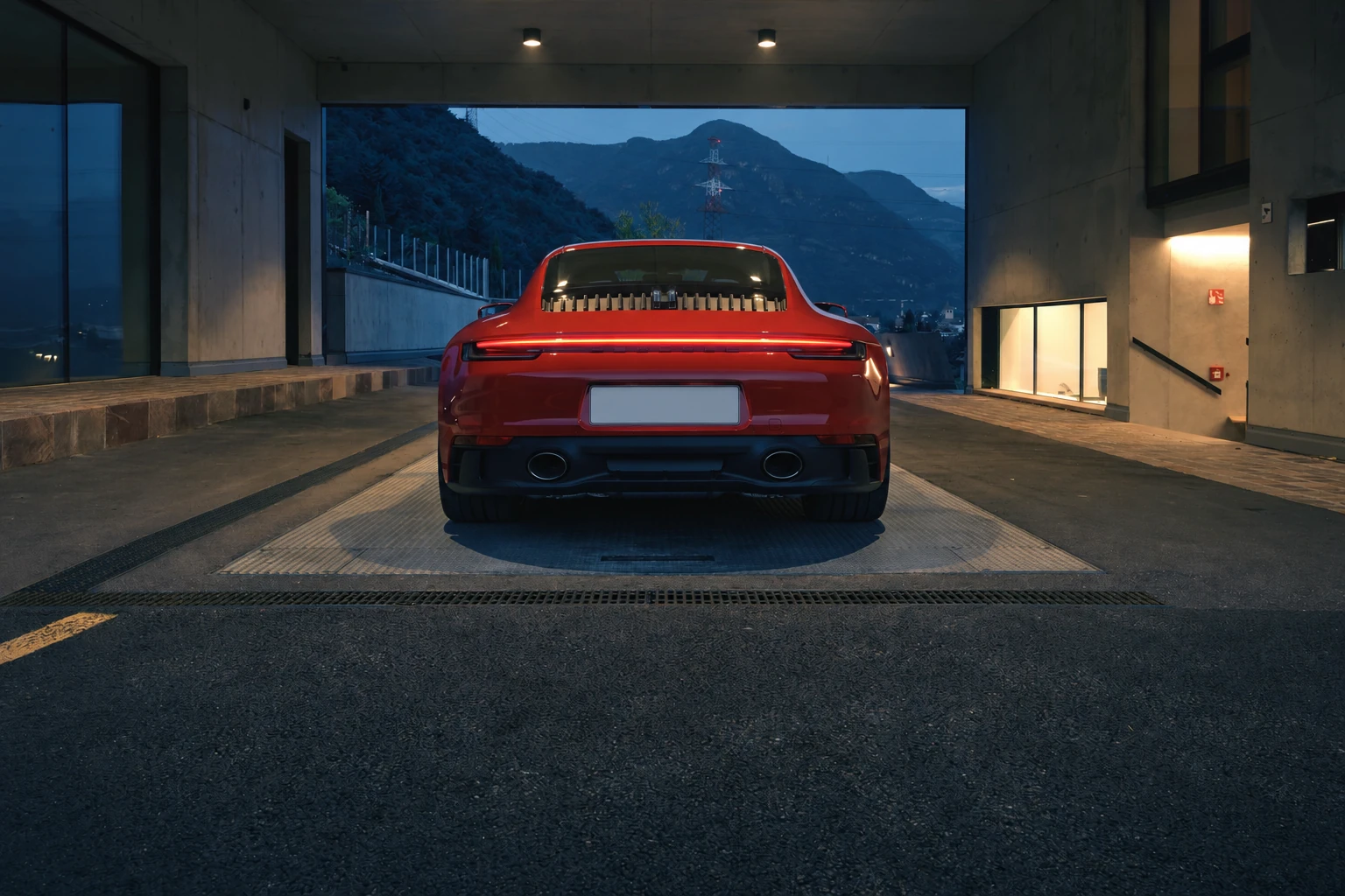 Красный Porsche 911 сзади у горной дороги